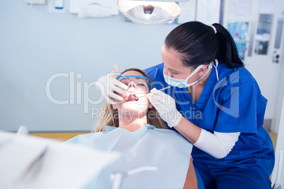 Dentist examining a patients teeth under bright light