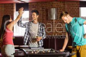 Happy friends playing table football