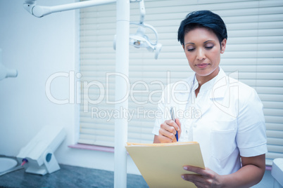 Female dentist reading reports