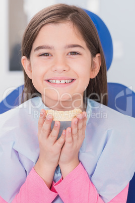 Smiling young patient holding teeth