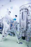 Scientist in protective suit climbing on ladder