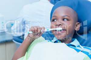 Boy brushing teeth in the dentists chair
