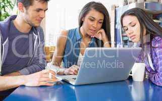 Young students doing assignment on laptop together