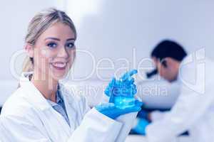 Science student holding blue chemical in beaker