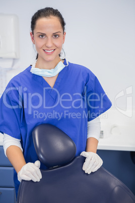 Portrait of a cheerful dentist behind a dentists chair