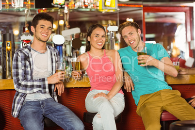 Smiling friends drinking beer together