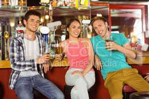 Smiling friends drinking beer together