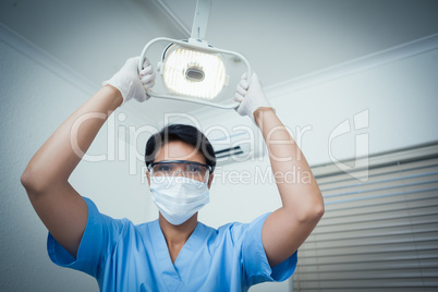 Female dentist adjusting light