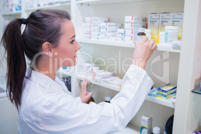 Smiling student taking jar from shelf