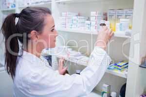 Smiling student taking jar from shelf