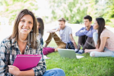 Happy students sitting outside on campus