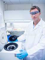 Chemist wearing safety glasses and using a centrifuge