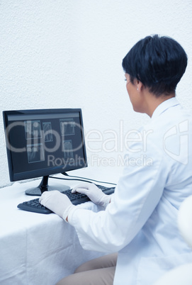 Dentist looking at x-ray on computer