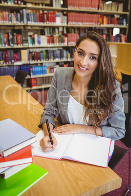 Smiling brunette student doing her assignment