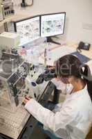 Biochemistry student using large microscope and computer