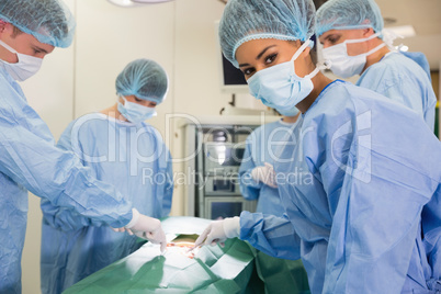 Medical student looking at camera during practice surgery