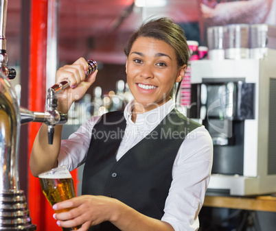 Pretty barmaid pulling pint of beer