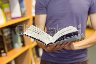University student standing holding textbook