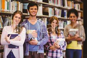 Happy students holding books in row