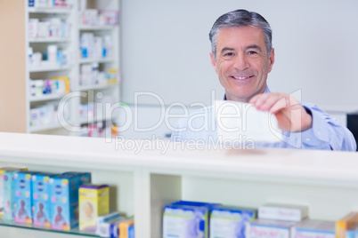 Pharmacist with grey hair holding a prescription