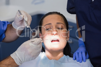 Dentist and nurse examining a scared patient