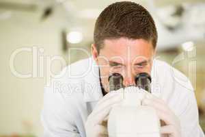 Young scientist working with microscope