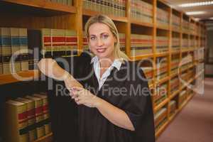 Smiling lawyer leaning on shelf