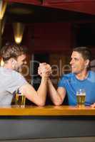 Happy friend arm wrestling each other