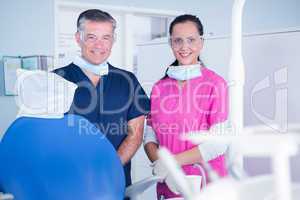 Smiling dentist and assistant with protective glasses