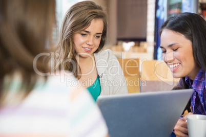 Young students doing assignment on laptop together