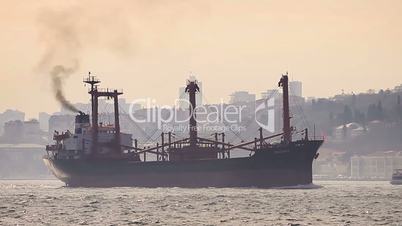 Marine air pollution. Istanbul in smog with a cargo ship