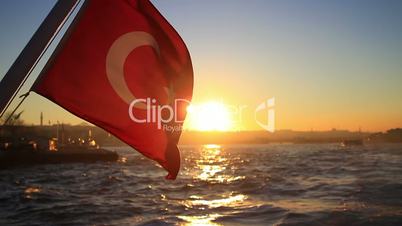 Turkish flag waving on the stern of an Istanbul Ship at sunset