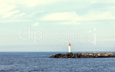 White lighthouse and stone pier