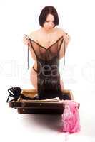 topless woman in front of open suitcase