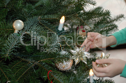 Kind schmückt den Tannenbaum