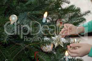 Kind schmückt den Tannenbaum