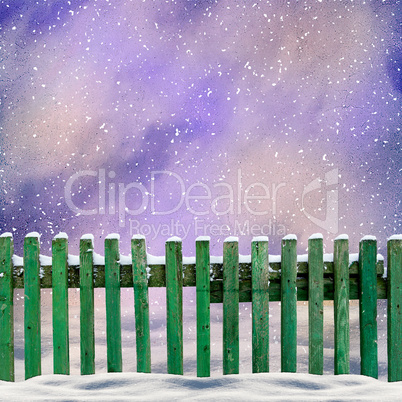 snowy old green wooden fence and falling snow