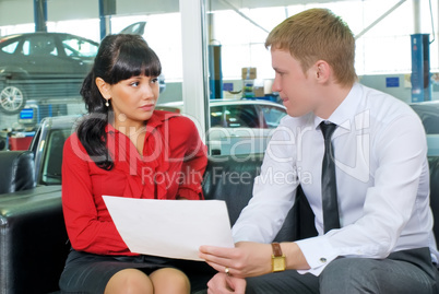 Attractive businesspeople in car shop