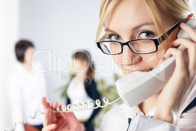 Attractive woman calls by wire phone in office