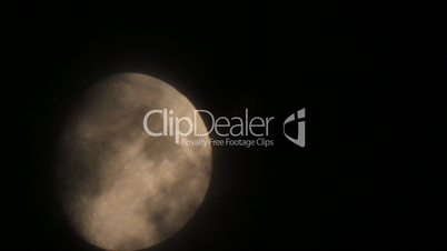 Moon disk through night dark mist