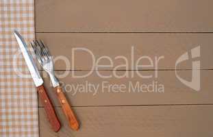 Knife and Fork on brown wooden background