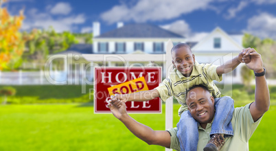 Father and Son In Front of Real Estate Sign and Home