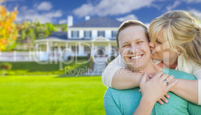 Happy Couple Hugging In Front of House