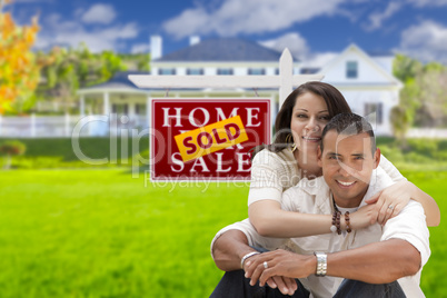 Hispanic Couple, New Home and Sold Real Estate Sign