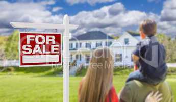 Family Facing For Sale Real Estate Sign and House