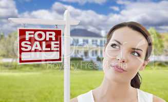 Thinking Woman In Front of House and For Sale Sign