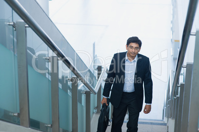 Asian Indian businessman ascending steps