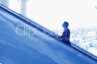 Indian businessman ascending escalator