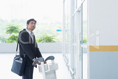 Indian businessman with airport trolley