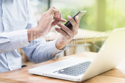 Businessman using smartphone and laptop computer